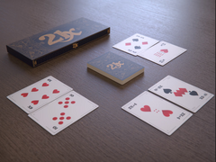 Photo of 21X box and cards laid out on a wooden table. The box is π times as wide as it is long, and has 21X on the front. The cards visible on the table are 6X, 10, 2X+4, N^3-2X, 24/X and 2N-2X, and each have different combinations of symbols on representing those quantities.