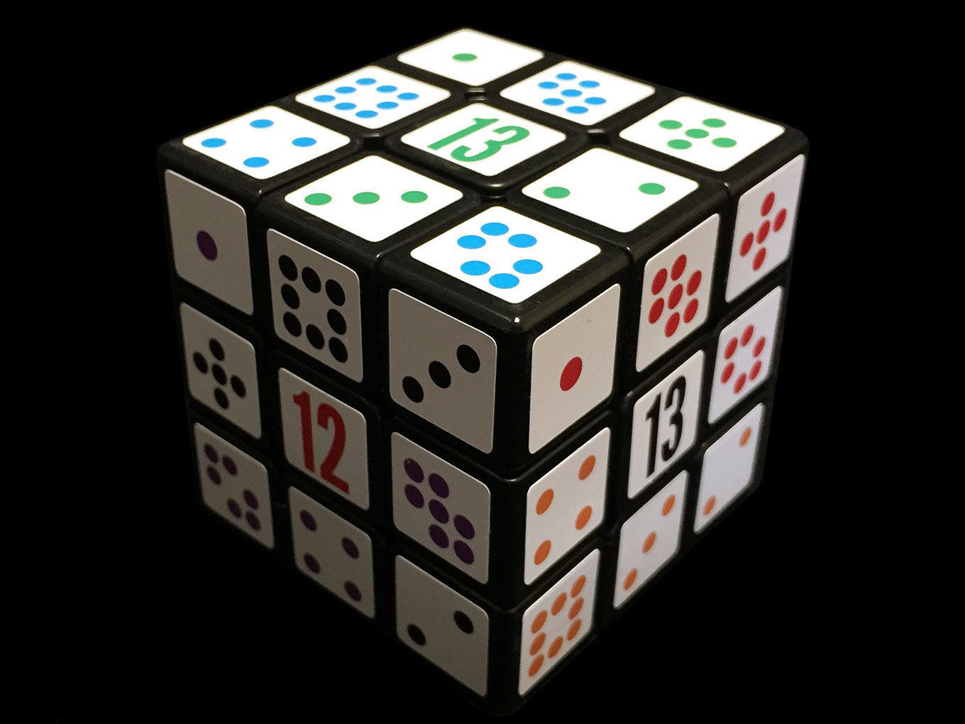 A photo of the Grime Cube solved for numbers - faces with the numbers 12, 13 and 13 are visible, and the dots around the sides add up to those totals along each edge