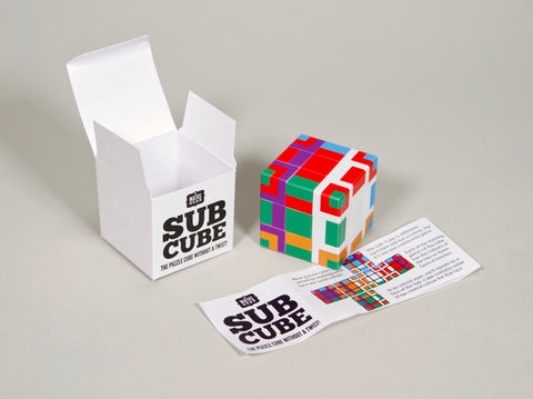 Photo of a Sub Cube next to its box and an instruction leaflete