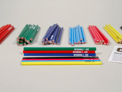 A photo of the pencil set showing one of each type of pencil in the foreground (red, green and blue square pencils for the X, Y and Z axes, and yellow, cyan, magenta and black hexagonal pencils for the other four axes)