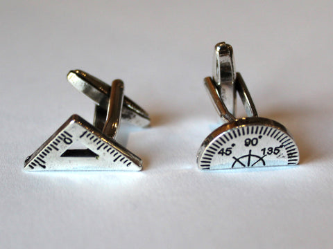 Photo of the pair of cufflinks, which are a metal set square and protractor